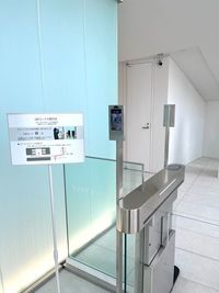 1階ゲート左側の読取り端末(カメラ)に、メッセージでお渡ししたQRコードをかざすとゲートが解錠しますので、通路左にあるエレベーターで2階にお上がりください - コワーキングスペースMangrove 【4名会議室】RoomDの入口の写真