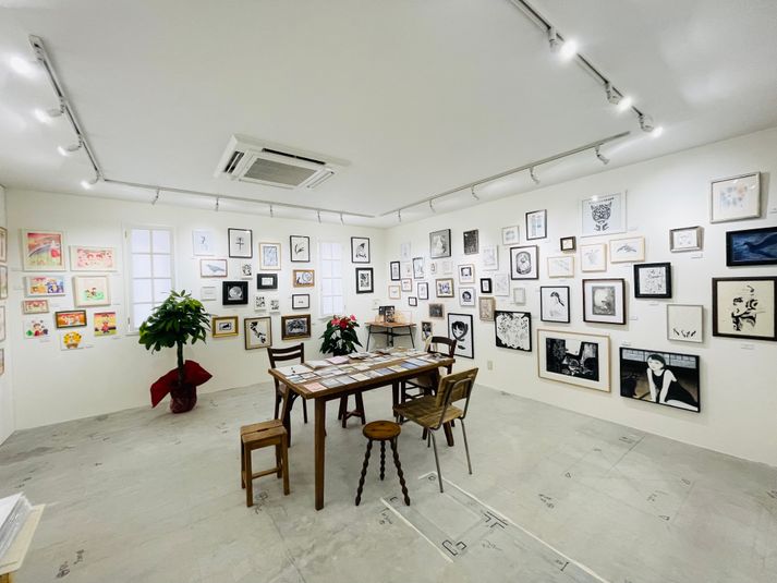 アンティークなテーブルと椅子、打ちっぱなしの床、白壁、ライトレール、絵画多数、 - artbook事務局のギャラリー ギャラリー・貸しスタジオの室内の写真